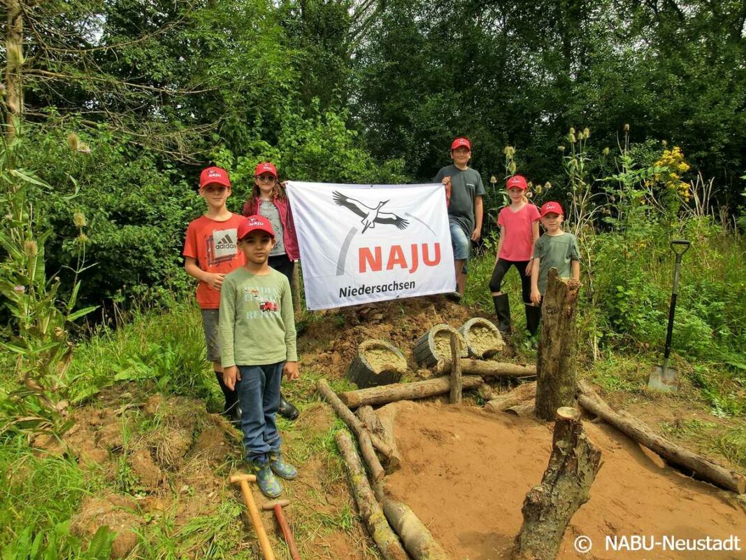 a group of kids standing in front of a sign